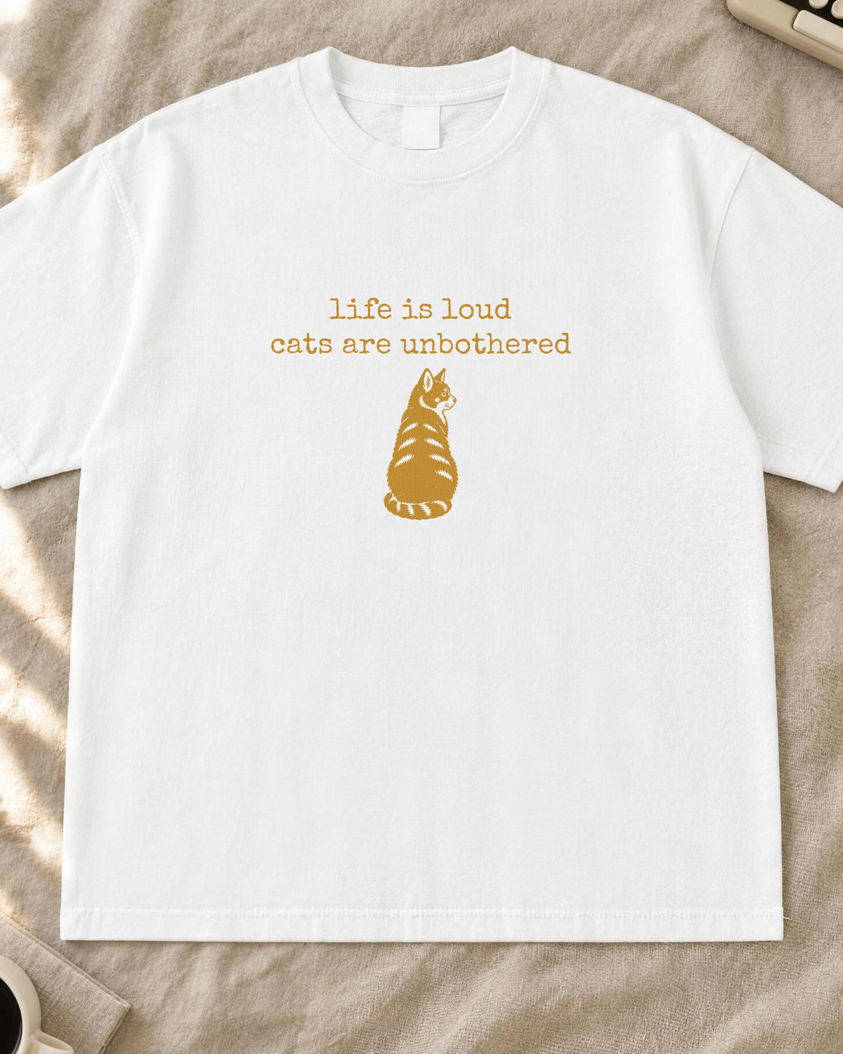 Cat shirt, life is loud cats are unbothered typewriter text with a cat sitting back-turned stamp print in mustard on a white Comfort Colors tee